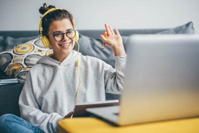 Young woman sitting a computer raising her hand