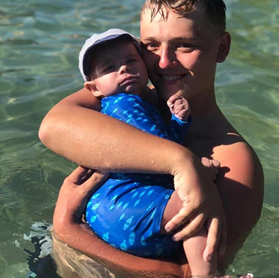Shawn holding infant in water