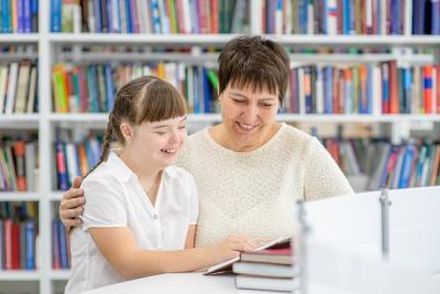 Adult and child reading in a library