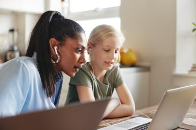 Woman and preteen sitting together looking at a laptop