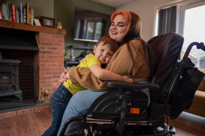Woman in a wheelchair hugging a child