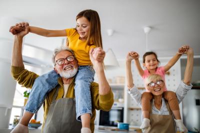 Young girl riding grandfathers shoulders