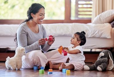 Caregiver with toddler with building blocks