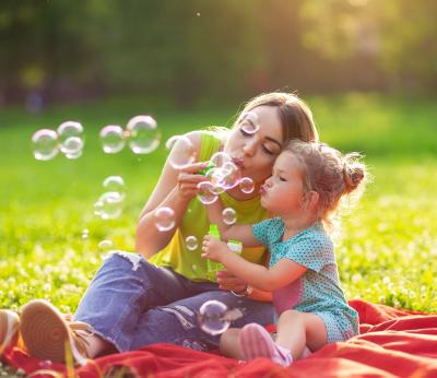 Caregiver and child blowing bubbles