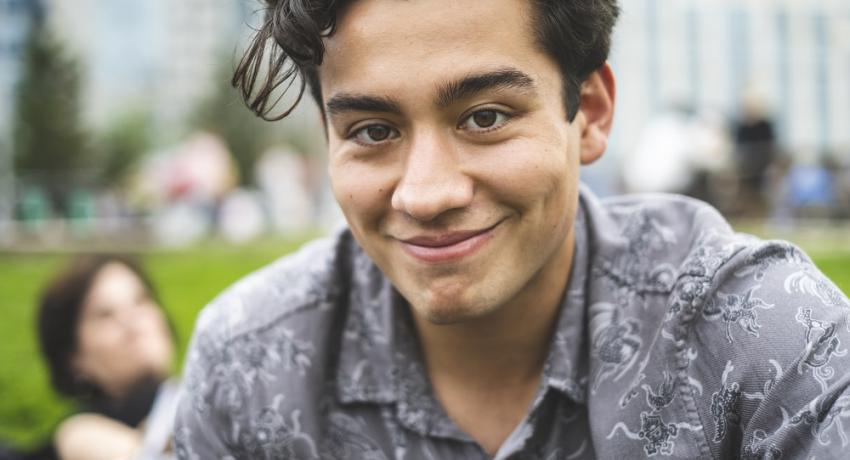 Young person smiling in outdoor setting. 