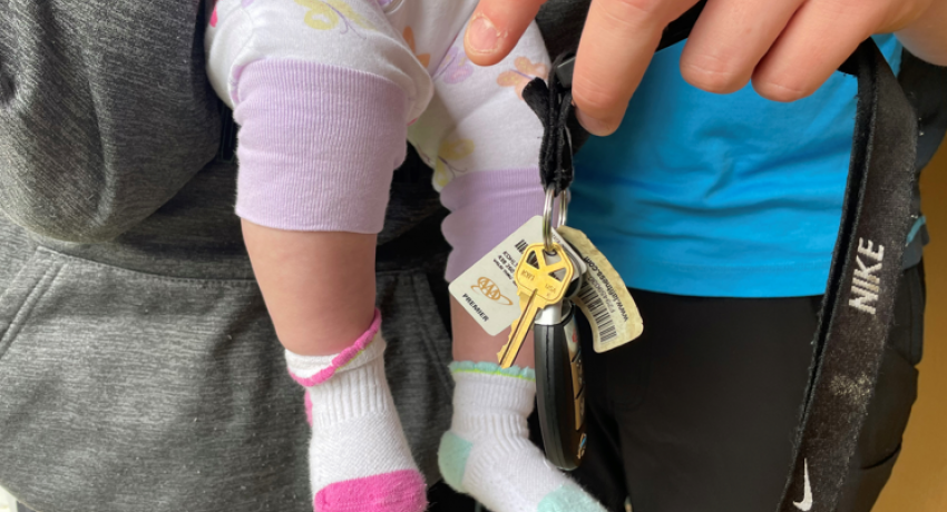 Young family holding infant and keys to their new home. 
