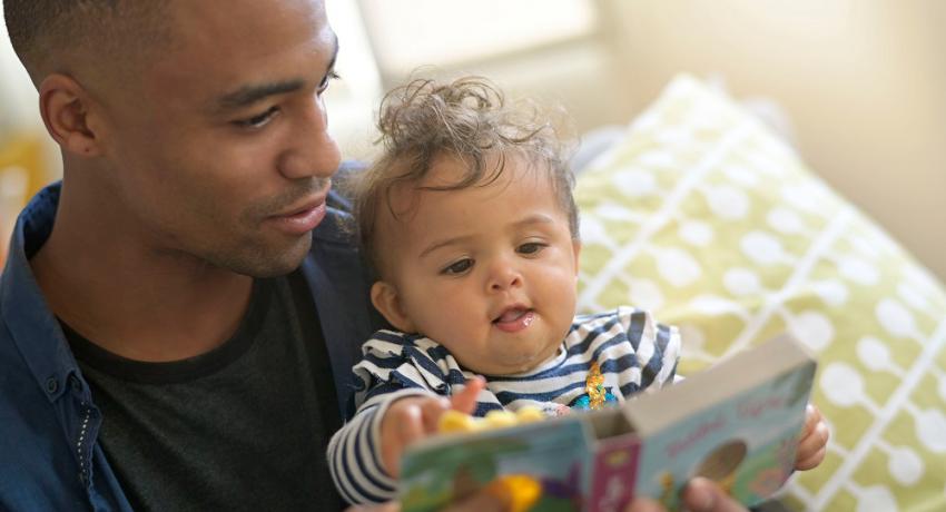 Young father reads to baby