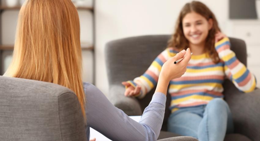 Psychologist working with teenage girl in office