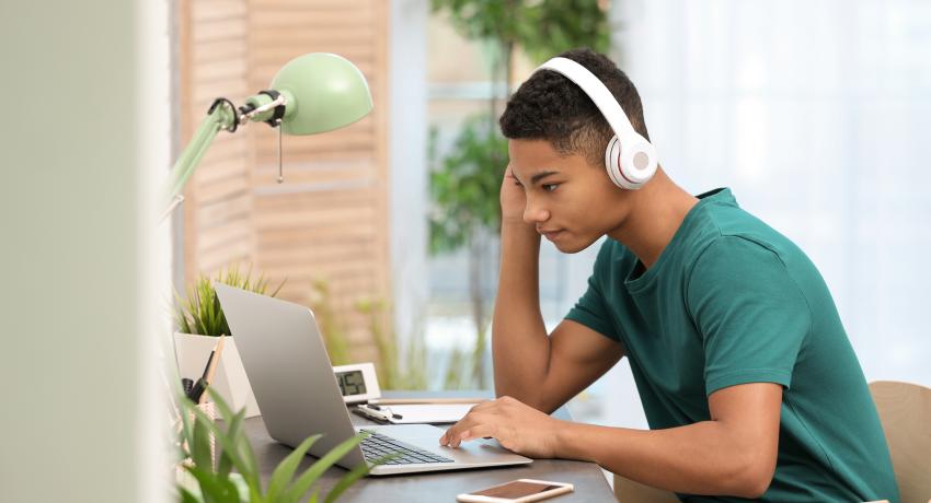 young person listening to computer 