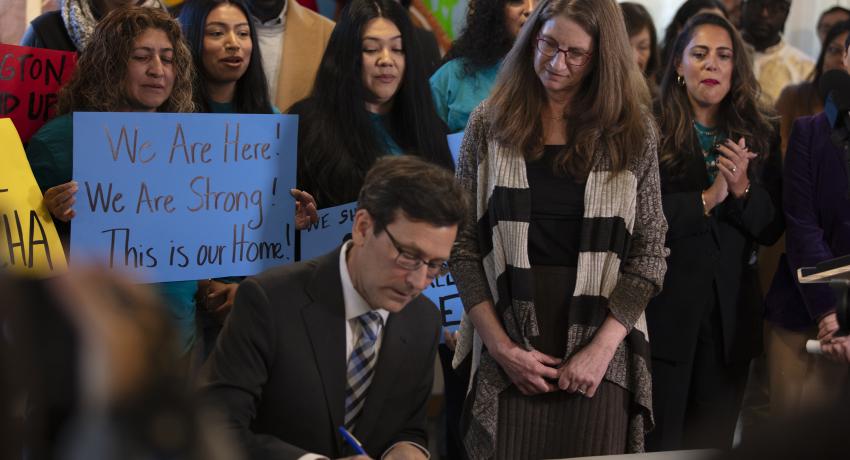 Gov. Bob Ferguson signs an Executive Order alongside DCYF Secretary Tana Senn.