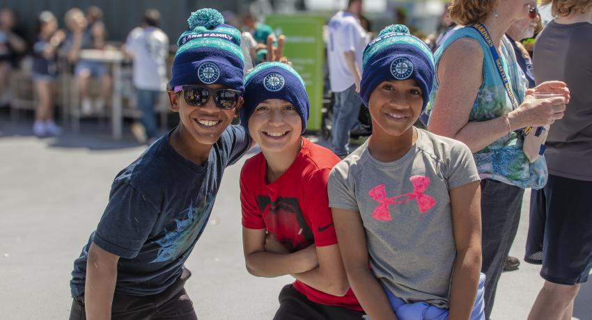 three kids smiling at the camera with matching hats