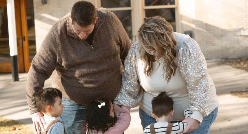 family of five standing in front of court house