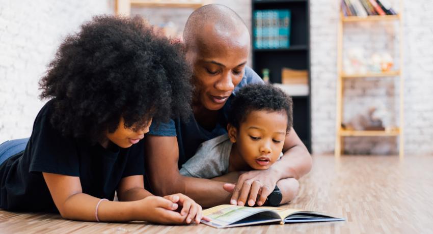 African American father reading a fairly tale fable story for kids at home