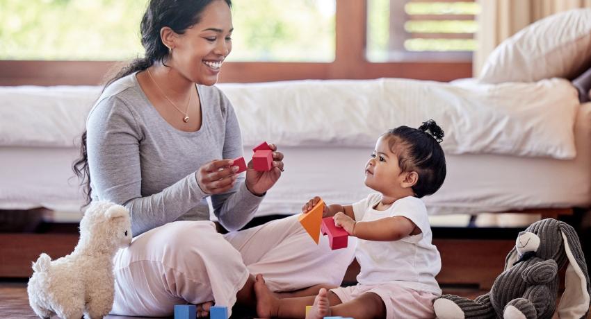 Caregiver with toddler with building blocks