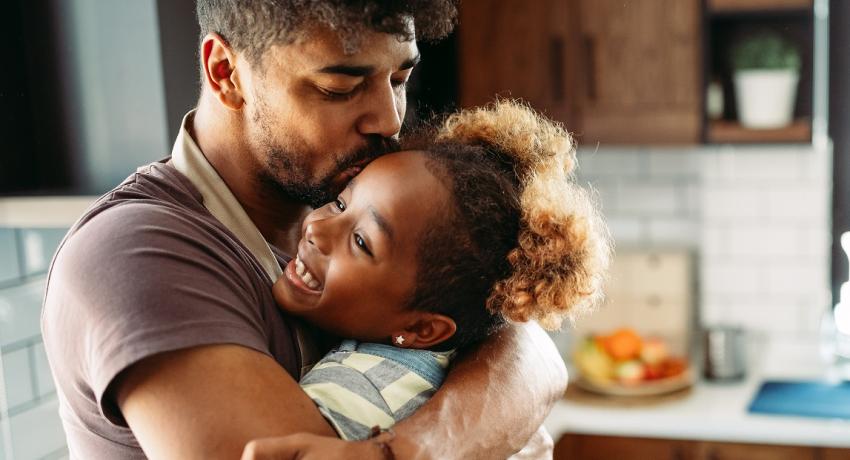 Father hugging daughter.