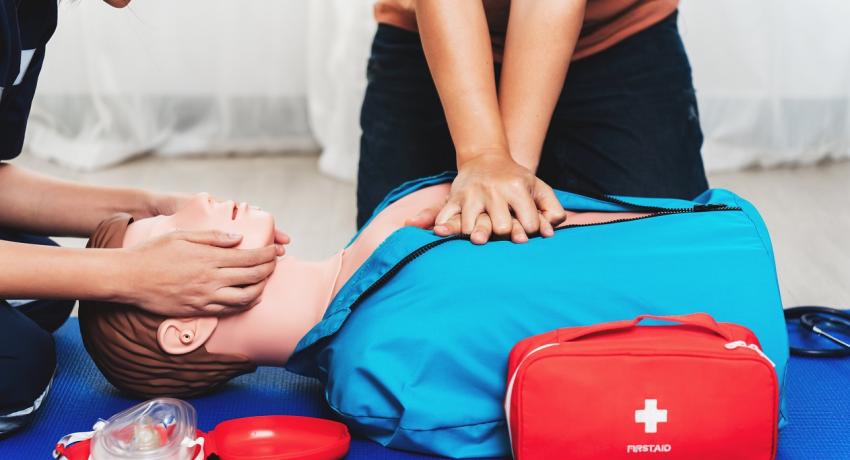 Person doing CPR chest compressions on a dummy